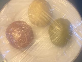 2、椰蓉开口酥,低粉180GG,黄油90G,红曲粉3G,抹茶粉3G。把油酥混合,分成三份,其中两份分别加入,抹茶粉和红曲粉。用保鲜膜包裹,松弛20分钟,