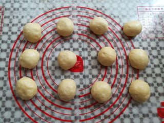 15、奶黄小餐包,面团取出轻压排气，平均分成12个小面团，滚圆盖上保鲜膜松弛15分钟