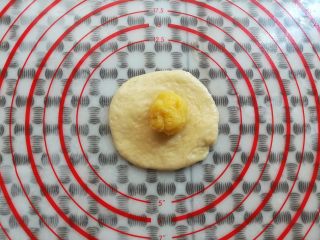 16、奶黄小餐包,取一个面团用擀面杖擀平放上奶黄馅