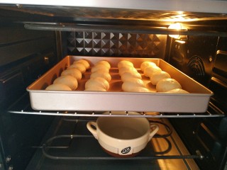 9、椰蓉牛奶小面包,将烤盘放入烤箱中，45°度二次发酵50分钟，记得在烤箱底部放一碗水，保持空气湿润