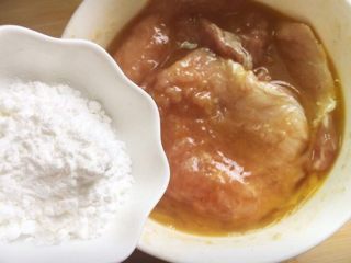 5、黄金猪排,把蛋液裹匀后接着加入生粉。