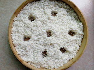 3、甜酒酿,将泡好的糯米滤干水分，放进蒸笼摊开铺平整（我这直径24厘米的蒸笼，用两层蒸刚刚好），中间用筷子弄几个洞，便于上汽，盖上盖子蒸三十分钟。