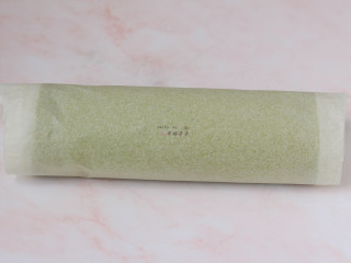 23、抹茶蛋糕卷,利用擀面杖反卷底部油纸的方式慢慢推送蛋糕片，使蛋糕片自然往前卷起，卷好后油纸包起整条蛋糕卷，收口朝下放置，送入冰箱冷藏1～2小时定型