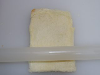 3、快手早餐—香肠吐司卷,用擀面杖将吐司擀薄,擀扁