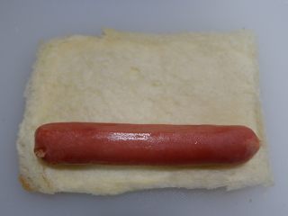 6、快手早餐—香肠吐司卷,将香肠摆上,香肠要切成跟吐司一样长短,我用的台式烤肠,长短正合适,不用切