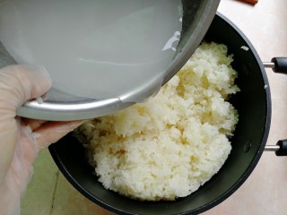 8、甜酒酿,再慢慢倒入酒曲水，让糯米饭均匀的裹到酒曲水（这一步我直接上手的，戴了手套，但要保证手套也是无油无水哦）