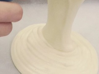 14、虎皮蛋糕卷,把混合好的面糊倒入铺了油纸的烤盘中，用刮板刮刮平，震出大气泡。