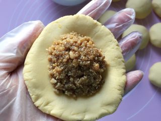 12、香煎花生南瓜饼,取一块面团，用手掌心按扁，放入花生馅儿。