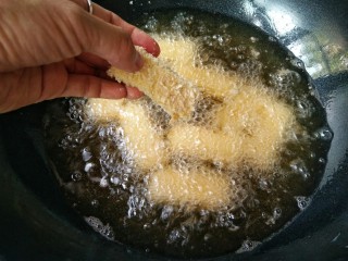 18、论牛奶的各种吃法之――脆皮炸鲜奶,锅中适量食用油（加拿大芥花油，味道中性，色质较轻，不会掩盖食材本身的味道与色泽；烟点达242摄氏度，能有效减少油烟等有害物质的产生）烧至5成热（用筷子在油锅中浸一下，筷子周围大量起小泡泡），将裹好面包糠的奶冻下油锅。