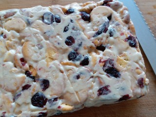 10、网红雪花酥,完全冷却后从烤盘里取出,用锯齿刀切自己想要的大小,撒上奶粉,雪花酥就完成啦