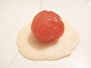 14、#甜味#凤梨蛋黄酥,把面团按扁，中间厚，两边薄，包上凤梨馅