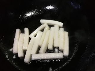 11、脆皮年糕,油热放入年糕条，中小火慢煎。