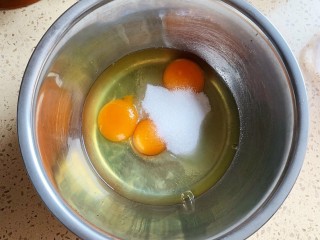2、抹茶千层蛋糕,打入鸡蛋，加入细砂糖，搅拌至细砂糖融化
