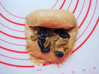 11、葡萄干红糖欧包,由上至下卷起来,边卷两端边向里收。