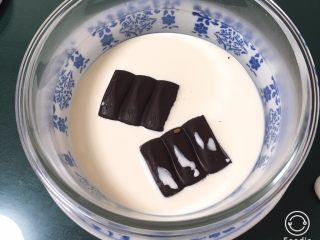 1、双色戚风蛋糕,巧克力和淡奶油放入玻璃碗中，大碗中倒入热水。