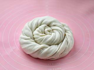 7、家常椒盐饼,然后从一头慢慢盘起来，尾部收到下面，用手轻轻按扁