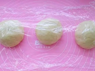 7、牛奶吐司,取出揉匀排气分成均匀的三份，覆盖保鲜膜松弛20分钟