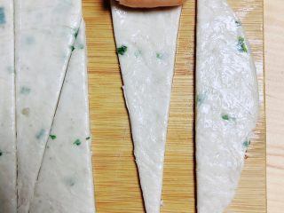 3、葱油飞饼香肠卷,将小香肠放入宽的一侧慢慢卷起来。