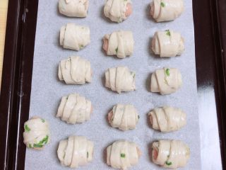 4、葱油飞饼香肠卷,一个个制作好，排在烤盘中。