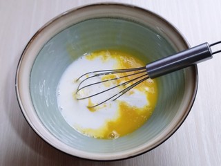 4、圣诞老人可可草莓杯子蛋糕,先做蛋黄糊，蛋黄用手动打蛋器打散，加入牛奶继续打均匀至看不到牛奶，加入玉米油，油和蛋液完全融合再一起。