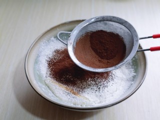 5、圣诞老人可可草莓杯子蛋糕,筛入面粉，可可粉用手动打蛋器拌均匀。