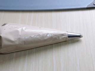 19、圣诞老人可可草莓杯子蛋糕,打发的奶油装入裱花袋中，如图。(记得先把裱花嘴放入裱花袋，再装奶油哈)