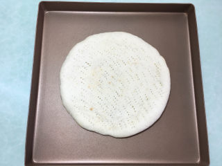 17、美味的牛排披萨,两个都做好后取一个烤好的披萨皮,放在烤盘里。