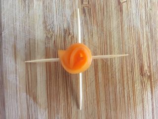 18、沙拉花束,取一片胡萝卜，对折后卷小卷，用两根牙签十字固定