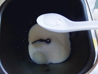 2、#甜味#毛毛虫豆沙面包,首先将牛奶倒入面包桶，再加入鸡蛋，糖和盐对角放。