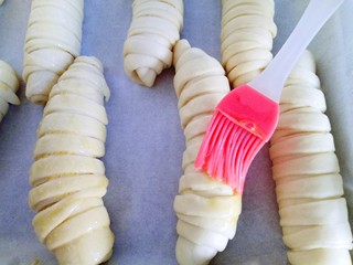 18、#甜味#毛毛虫豆沙面包,发酵好的面包胚取出全部刷上蛋液。