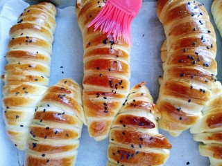 21、#甜味#毛毛虫豆沙面包,戴上隔热手套取出烤盘，立即刷上一层玉米油，这样会更好的锁住面包的水份。