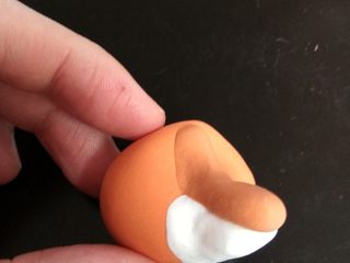 14、疯狂动物城翻糖杯蛋糕,制作狐狸：白色翻糖皮用牙签调入少许橘色色素，抻拉揉匀。捏一个小球，鼻子和嘴部如图捏好。