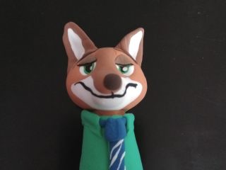 17、疯狂动物城翻糖杯蛋糕,处理好眉毛等细节。如图，绿色擀成薄片，包裹住身体。