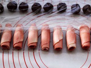 14、桃花朵朵开-桃花酥,再一次卷起，盖上保鲜膜，再次松弛15分钟。