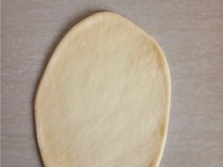 8、日式牛奶卷,取一个小面团拍扁排气，擀成长椭圆形。