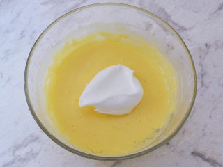 9、半熟芝士蛋糕,将三分之一的蛋白放入蛋黄糊中翻拌均匀