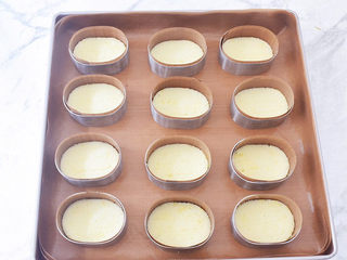 27、半熟芝士蛋糕,再把蛋糕片放入模具中,模具边缘用配套的半熟芝士围边油纸围一圈,放入烤盘中