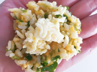 7、香菜芝士饭团～剩米饭也有春天,去掉手套，把手上抹一点油，用勺子挖一勺米饭在手上压扁，中间放一点芝士碎