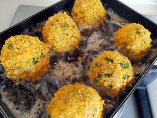 12、香菜芝士饭团～剩米饭也有春天,放入饭团，中小火炸至饭团成金黄色关火，期间用筷子翻滚饭团，让饭团上色均匀（如果一锅炸不完，就把炸好的饭团取出来）