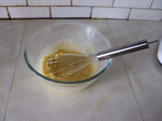 3、小巧杯子蛋糕,然后加入蛋黄与牛奶搅拌均匀。