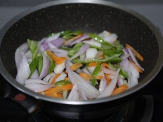 8、酱爆鱿鱼圈,放入胡萝卜、洋葱、青椒翻炒