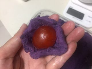 3、广式月饼（紫薯蛋黄馅）,把蛋黄包进紫薯泥里。