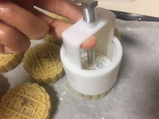 8、广式月饼（紫薯蛋黄馅）,慢慢挤压模具，最后把月饼脱膜在烤盘上。
