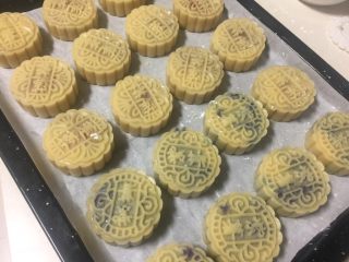 10、广式月饼（紫薯蛋黄馅）,月饼全部做好整齐的码在烤盘上。可用小喷壶在表面少许喷点水，防止烤的过程开裂。