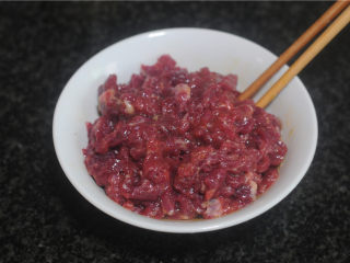 2、剁椒牛肉,在肉片中加入少许盐、黑胡椒粉、红酒、鸡蛋拌匀