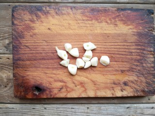 6、辣炒肥肠,蒜去皮去蒂切滚刀块。