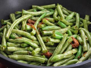 7、豆角焖面,接着放入豆角翻炒均匀