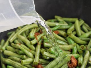 8、豆角焖面,再添入适量的清水没过豆角，大火煮开后改中火炖20到30分钟