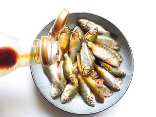 2、家乡特色美食——杂鱼炖小豆饼,倒入少许生抽、料酒抓匀腌渍15分钟，