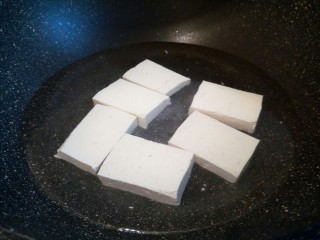 4、豆腐肉丸子,锅里加水，加适量盐，把豆腐焯水，去除豆腥味，盛盘，放凉